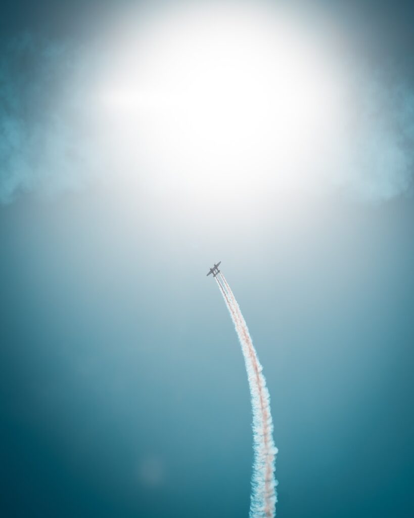 a jet flying through the sky leaving a trail of smoke